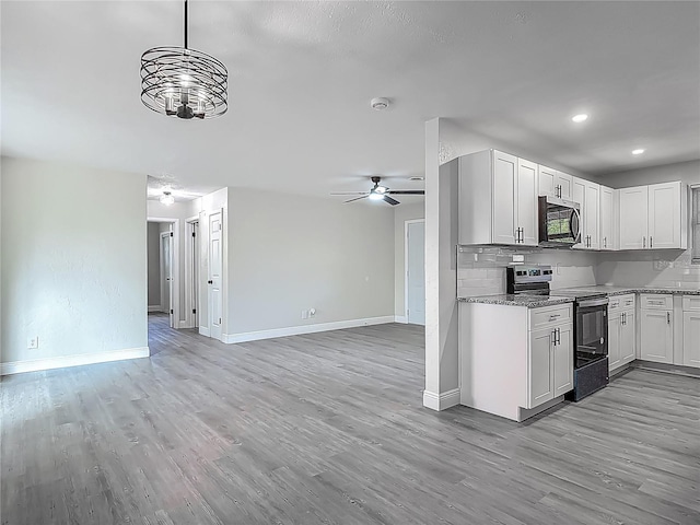 1298 Scottsdale Dr, Ormond Beach, FL 32174 - kitchen featuring electric range oven, stainless steel microwave, open floor plan, baseboards, and light wood-type flooring