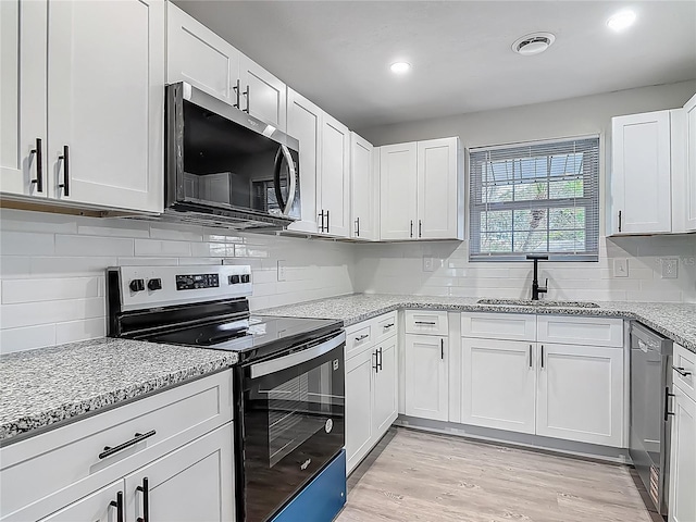1298 Scottsdale Dr, Ormond Beach, FL 32174 - kitchen featuring decorative backsplash, white cabinetry, light stone counters, a sink, and appliances with stainless steel finishes