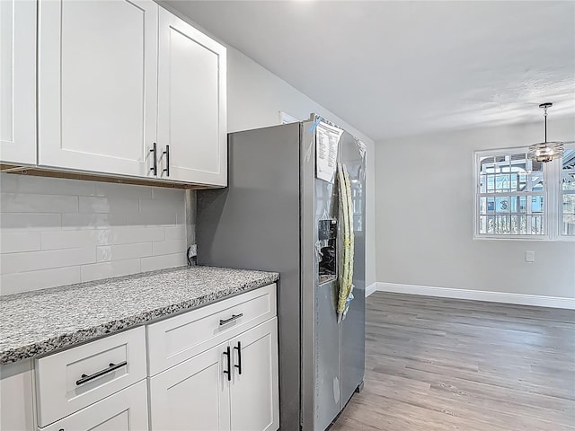 1298 Scottsdale Dr, Ormond Beach, FL 32174 - kitchen with white cabinets, light wood finished floors, stainless steel fridge with ice dispenser, baseboards, and tasteful backsplash