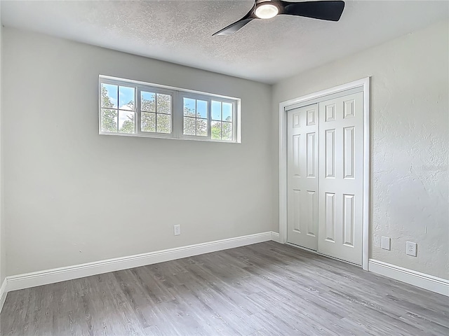 1298 Scottsdale Dr, Ormond Beach, FL 32174 - unfurnished bedroom featuring baseboards, a textured ceiling, wood finished floors, and a closet