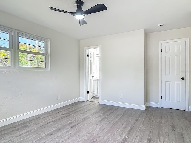 1298 Scottsdale Dr, Ormond Beach, FL 32174 - unfurnished bedroom with baseboards, a ceiling fan, ensuite bath, and wood finished floors