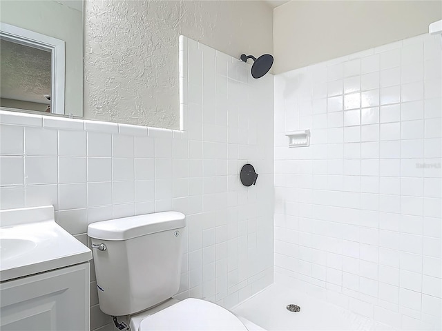 1298 Scottsdale Dr, Ormond Beach, FL 32174 - full bath featuring vanity, a textured wall, toilet, tile walls, and a tile shower