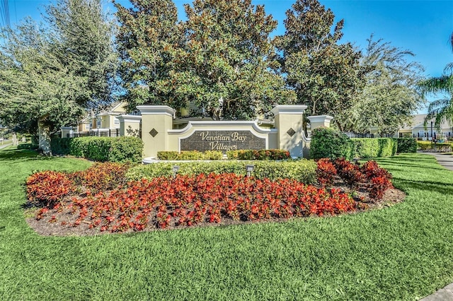 community sign with fence and a yard