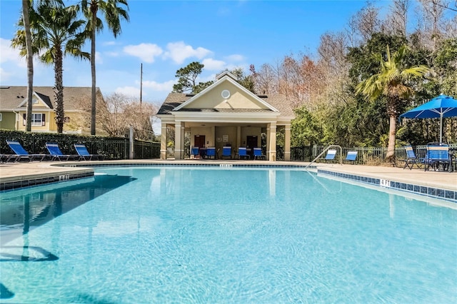 pool featuring fence and a patio area