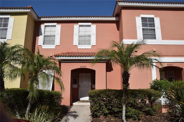mediterranean / spanish-style house featuring stucco siding and a tile roof