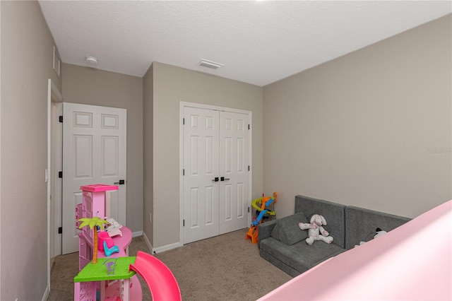 carpeted bedroom featuring visible vents, baseboards, and a closet