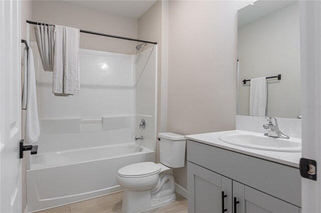 bathroom with vanity, wood finished floors, toilet, and shower / washtub combination