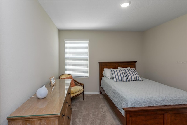 bedroom featuring baseboards and light carpet