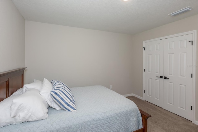 bedroom featuring a closet, baseboards, carpet flooring, and visible vents