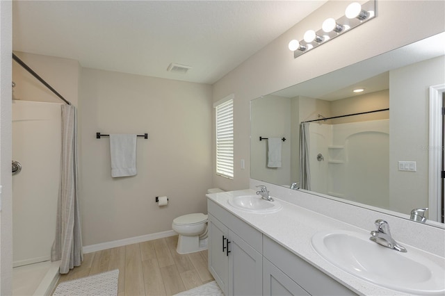 full bath featuring visible vents, a sink, a shower with shower curtain, and wood finished floors