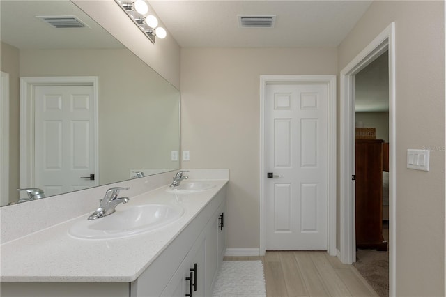 bathroom featuring double vanity, visible vents, and a sink