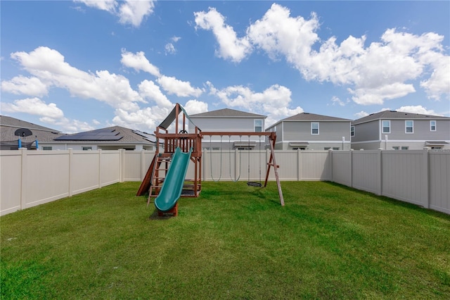 view of yard featuring a residential view, a fenced backyard, and a playground
