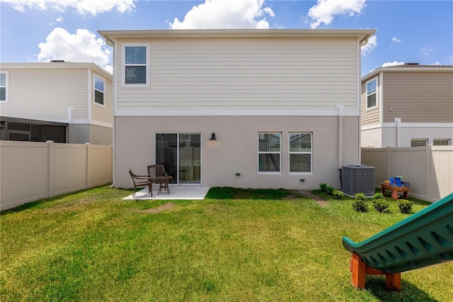 back of property with central air condition unit, a fenced backyard, a yard, a patio, and stucco siding