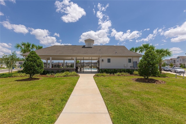 exterior space featuring a lawn, fence, and stucco siding