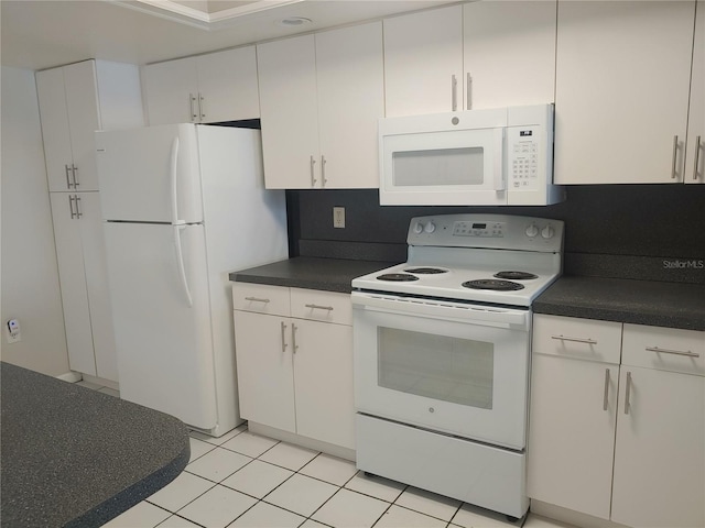 4109 Fairview Vista Pt Unit 315, Orlando, FL 32804 - kitchen with dark countertops, light tile patterned flooring, white cabinets, and white appliances