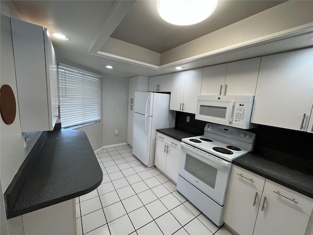 4109 Fairview Vista Pt Unit 315, Orlando, FL 32804 - kitchen with dark countertops, a raised ceiling, white appliances, recessed lighting, and light tile patterned floors