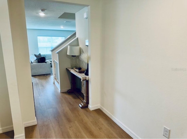 hall with wood finished floors and baseboards