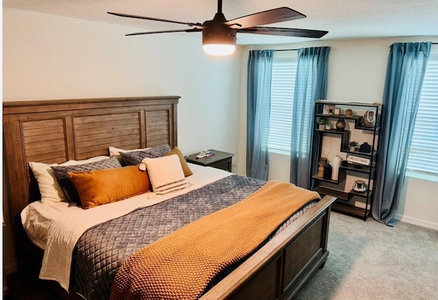 bedroom featuring light colored carpet, ceiling fan, and baseboards