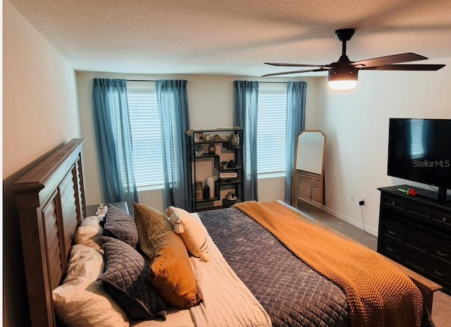 carpeted bedroom featuring multiple windows, ceiling fan, baseboards, and a textured ceiling