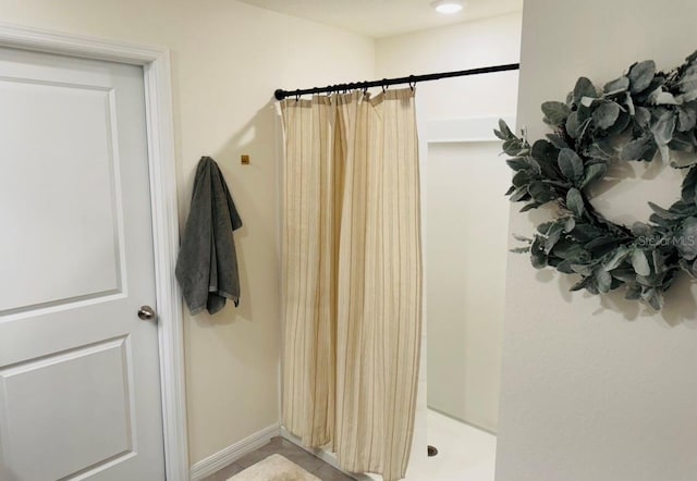bathroom with a shower with curtain and baseboards