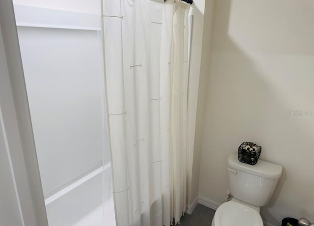 bathroom featuring curtained shower and toilet