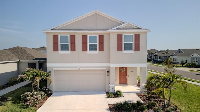 view of front facade with driveway, stucco siding, a garage, and a residential view