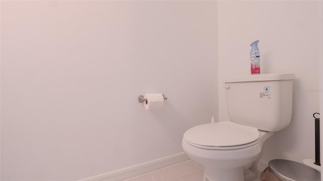 bathroom with toilet, tile patterned floors, and baseboards