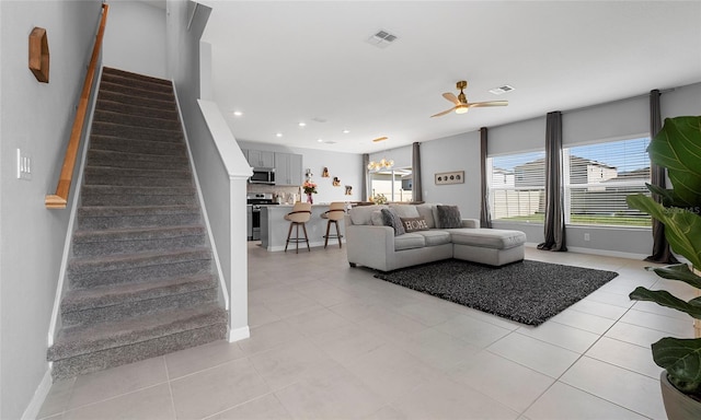 living area featuring plenty of natural light, a ceiling fan, stairway, recessed lighting, and light tile patterned floors