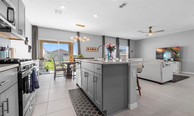 kitchen with appliances with stainless steel finishes, a sink, gray cabinets, plenty of natural light, and recessed lighting