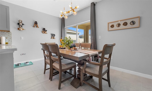 dining area with a chandelier, baseboards, and light tile patterned floors