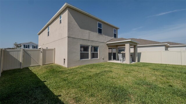 back of house featuring stucco siding, a patio area, and a gate