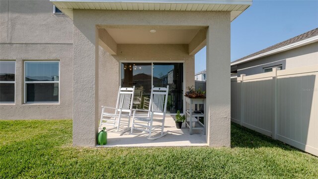 property entrance with stucco siding and a patio