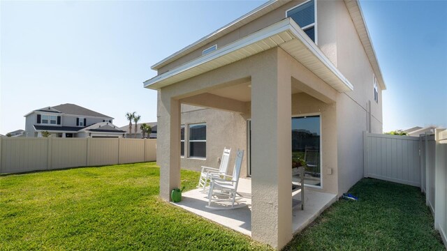 rear view of house featuring stucco siding and a patio area