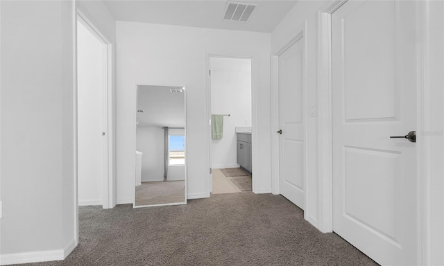 corridor featuring light carpet and baseboards