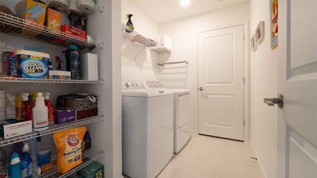washroom featuring light tile patterned floors, independent washer and dryer, and baseboards