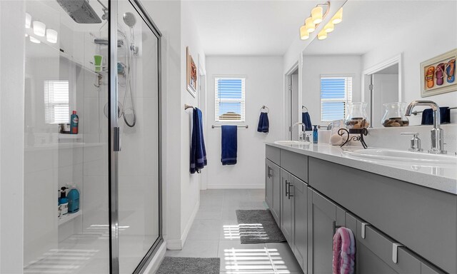 full bathroom featuring tile patterned flooring, a shower stall, double vanity, and a chandelier
