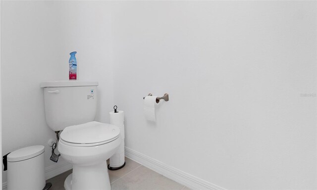 bathroom featuring toilet, tile patterned floors, and baseboards