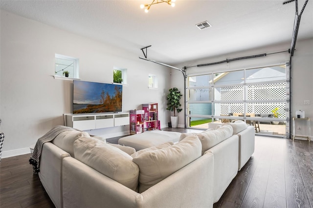 living room with a healthy amount of sunlight, baseboards, dark wood-style flooring, and visible vents