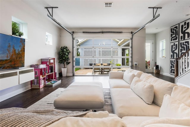 living room with visible vents, baseboards, and wood finished floors