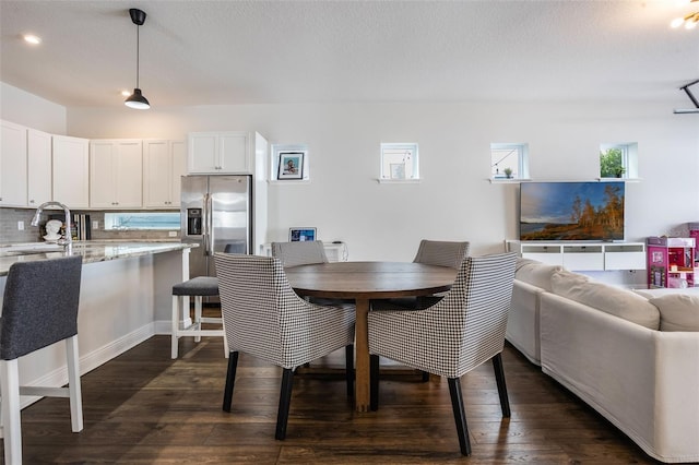 dining room featuring dark wood-style floors and a textured ceiling