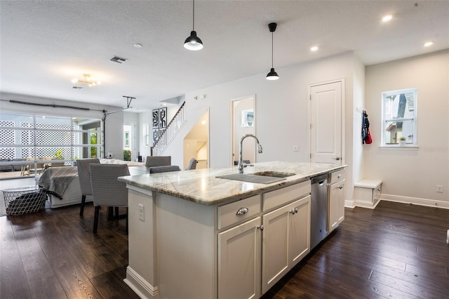 kitchen with a sink, dark wood finished floors, open floor plan, and dishwasher