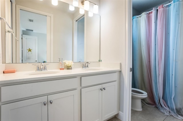bathroom with visible vents, a sink, tile patterned flooring, and double vanity