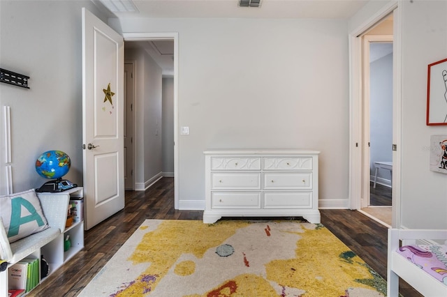 bedroom featuring visible vents, attic access, dark wood-style flooring, and baseboards