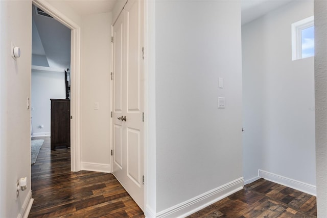 hallway with baseboards, visible vents, and dark wood-style floors