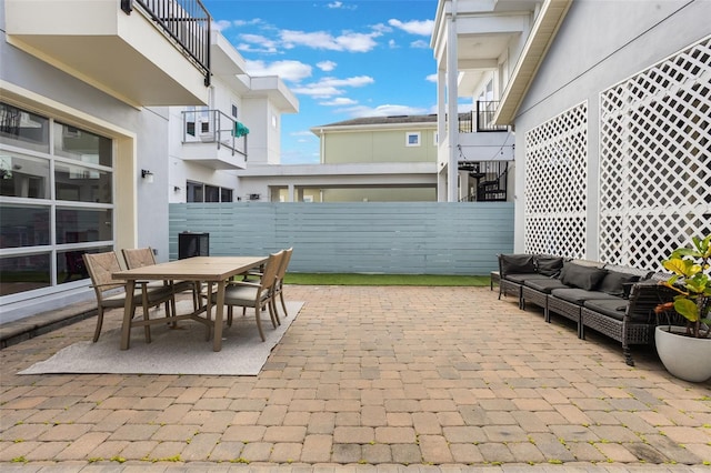 view of patio / terrace featuring fence, an outdoor living space, and outdoor dining area
