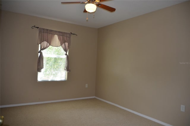 carpeted empty room featuring baseboards and a ceiling fan