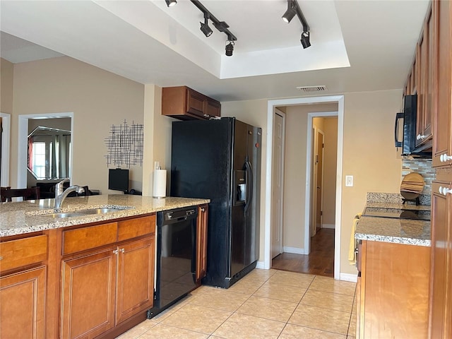 909 Royalton Rd, Orlando, FL 32825 - kitchen featuring black appliances, a sink, brown cabinets, rail lighting, and light stone counters