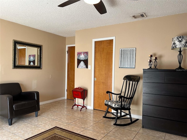 909 Royalton Rd, Orlando, FL 32825 - living area with a ceiling fan, a textured ceiling, light tile patterned floors, and baseboards