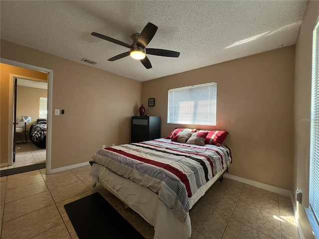 909 Royalton Rd, Orlando, FL 32825 - bedroom featuring light tile patterned floors, a textured ceiling, ceiling fan, and baseboards