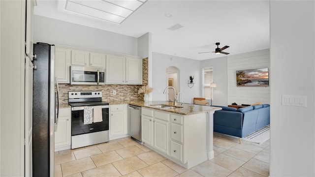 726 Lake Biscayne Way, Orlando, FL 32824 - kitchen with appliances with stainless steel finishes, a sink, a peninsula, open floor plan, and arched walkways